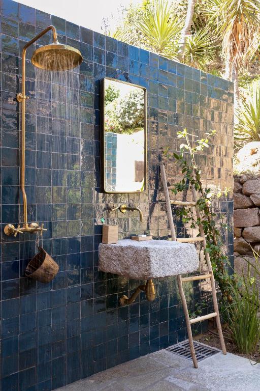 a blue tiled bathroom with a sink and a mirror at Domaine Santa Giulia Palace in Porto-Vecchio
