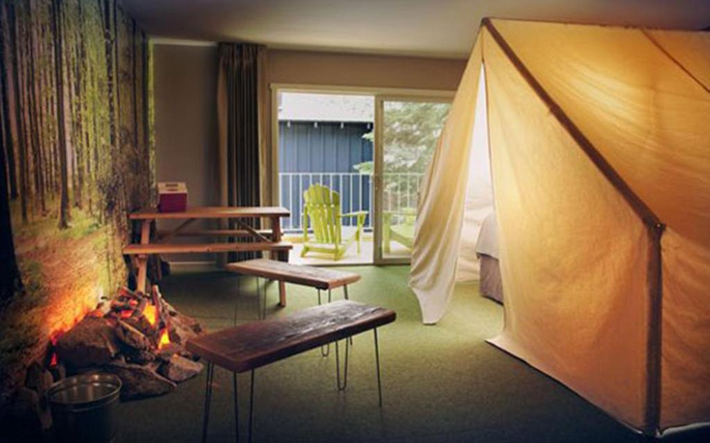 a living room with a tent and a fireplace at Basecamp Tahoe South in South Lake Tahoe