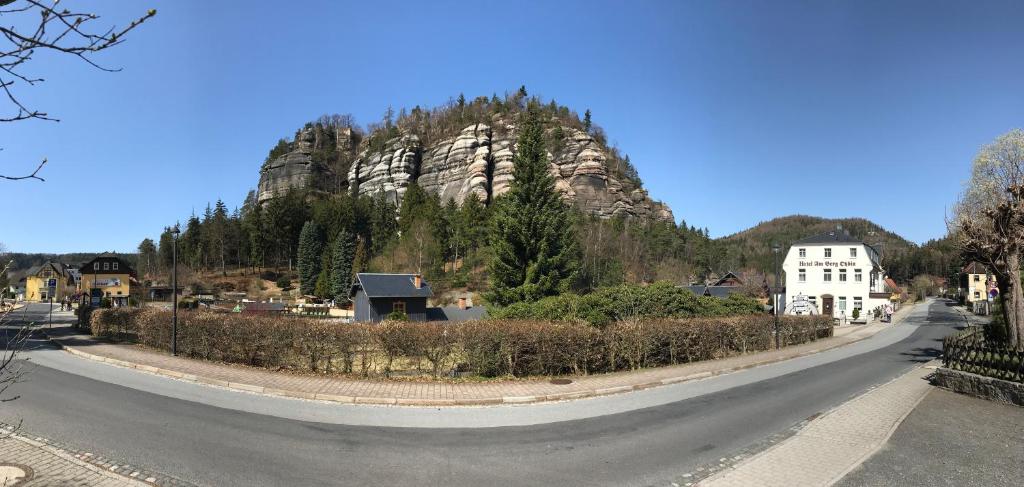 a winding road in front of a mountain at Hotel am Berg Oybin garni in Kurort Oybin