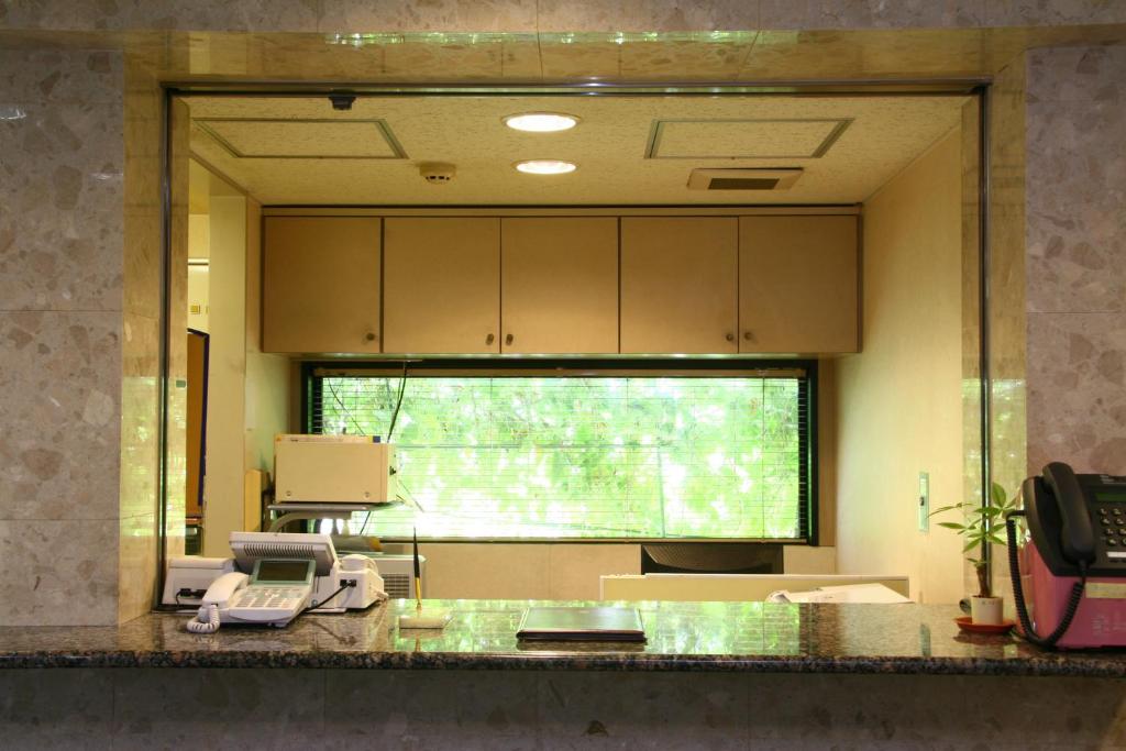 um quarto de hospital com um telefone no balcão em Accecss Tenjin em Fukuoka