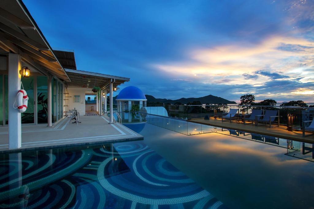 a view of a swimming pool at dusk at Costa Village Bangsaray in Bang Sare