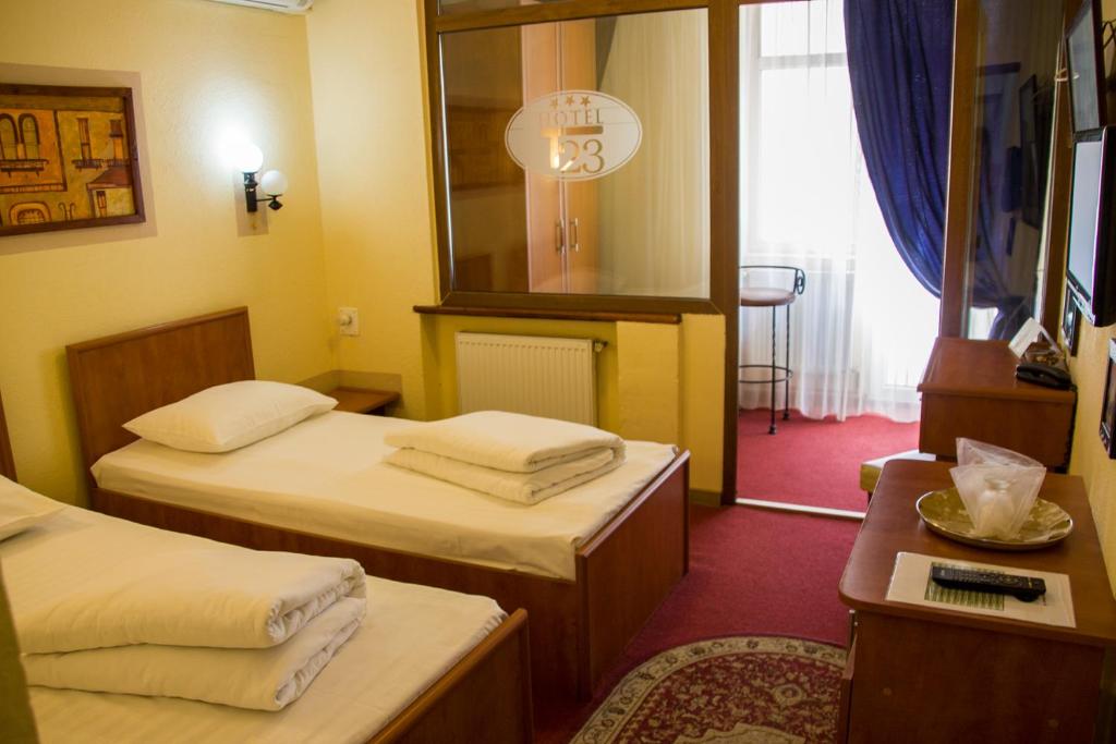 a hotel room with two beds and a mirror at HOTEL T23 srl in Iaşi