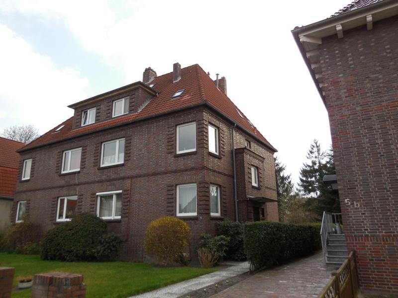 een bruin bakstenen huis met witte ramen op een tuin bij Eg in Wilhelmshaven