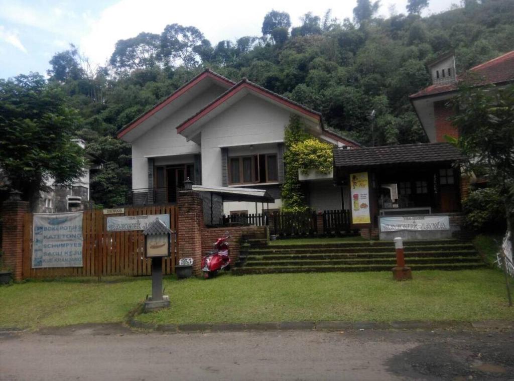 una casa con una moto parcheggiata di fronte di Villa Triniti Blok i-35 a Bandung