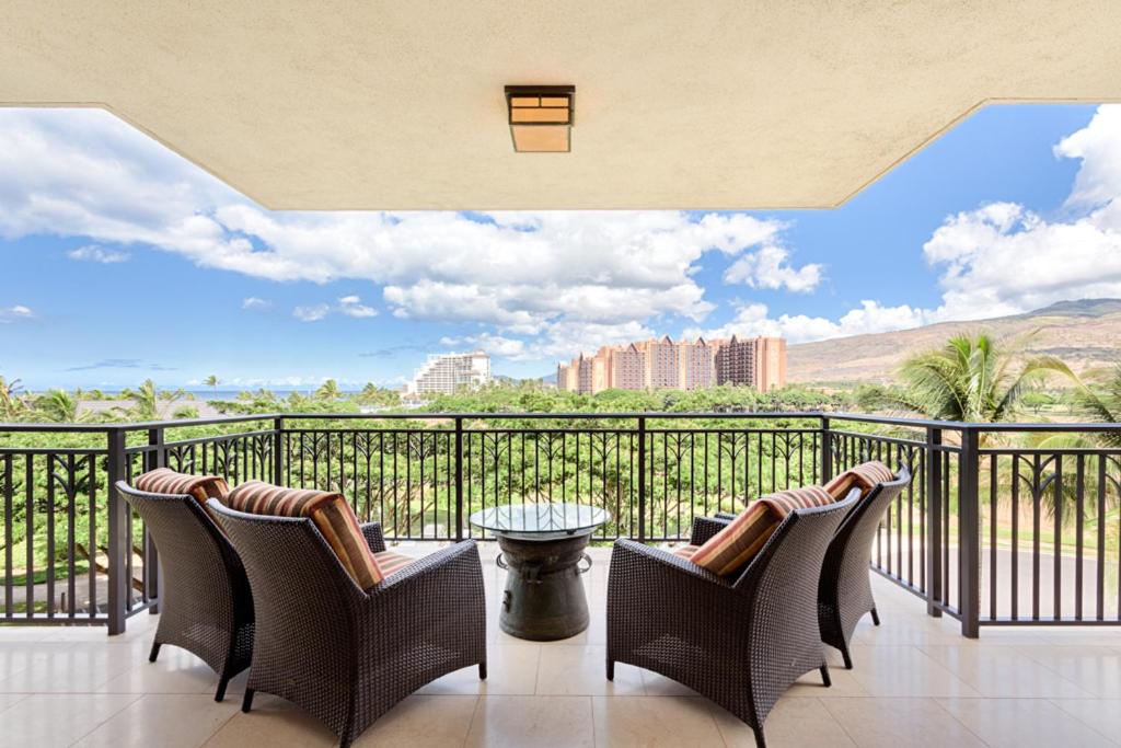 a balcony with chairs and a view of the city at Fifth Floor UPGRADED Villa with Sunset View - Beach Tower at Ko Olina Beach Villas Resort in Kapolei