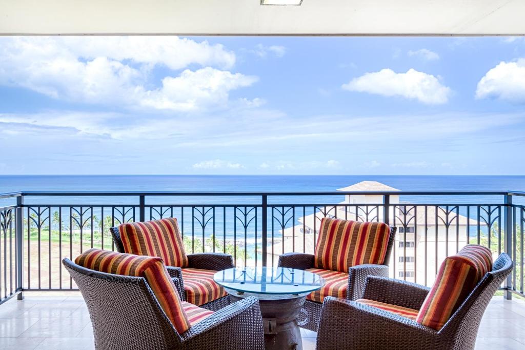 TOP Floor Penthouse with Panoramic View - Ocean Tower at Ko Olina Beach Villas Resort في كابولي: بلكونه فيها كرسيين وطاولة والمحيط