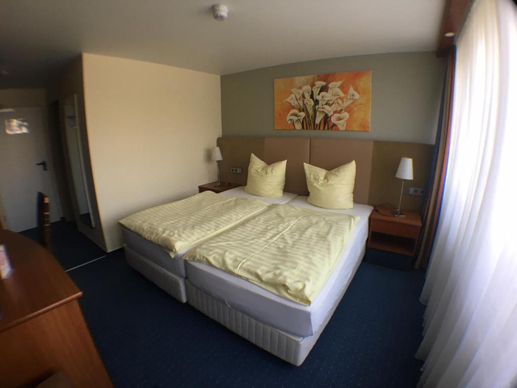 アッシャースレーベンにあるMotel Monteurのベッドルーム1室(大型ベッド1台、白いシーツ、枕付)