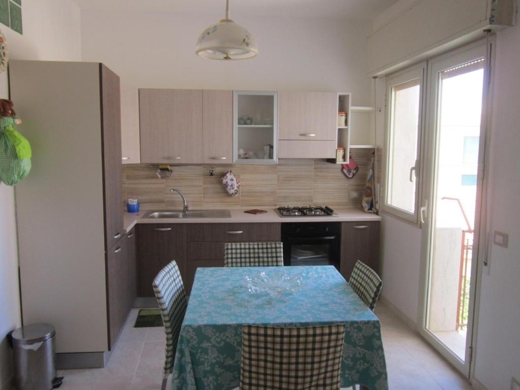 a kitchen with a table with a blue table cloth on it at Appartamento centralissimo Marina di Ragusa in Marina di Ragusa