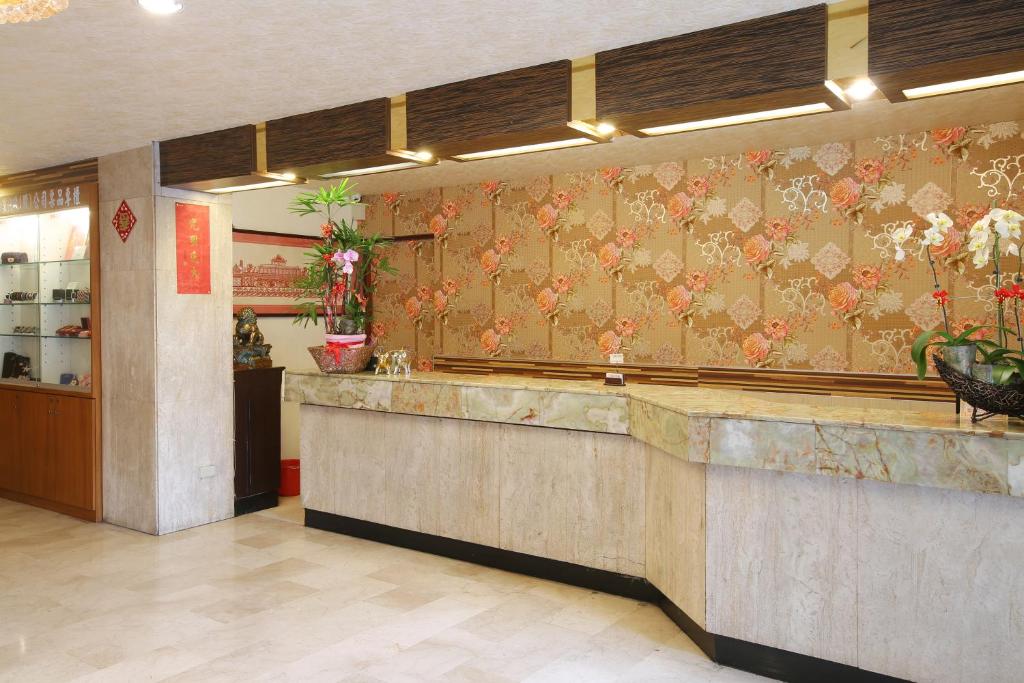 a restaurant lobby with a counter and floral wallpaper at Chiayi Crown Hotel in Chiayi City