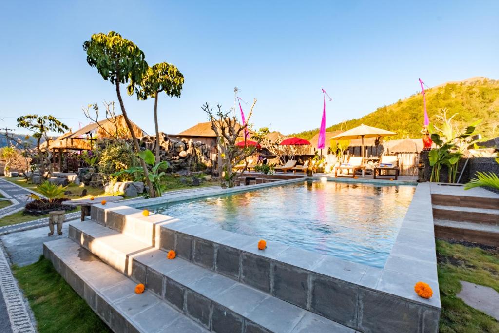 a swimming pool at a resort with a mountain in the background at Latengaya Mount Batur View Bungalow in Kintamani