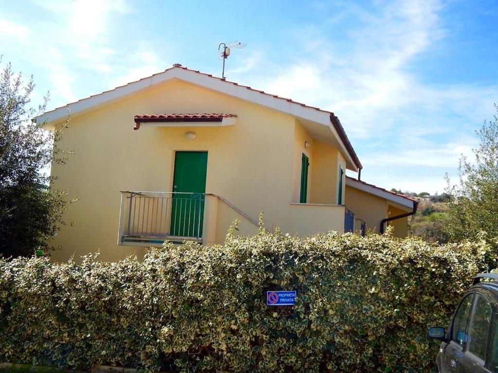 a yellow house with a green door and a fence at N148 - Numana, nuovo trilocale con terrazzo a 350 metri dal mare in Numana
