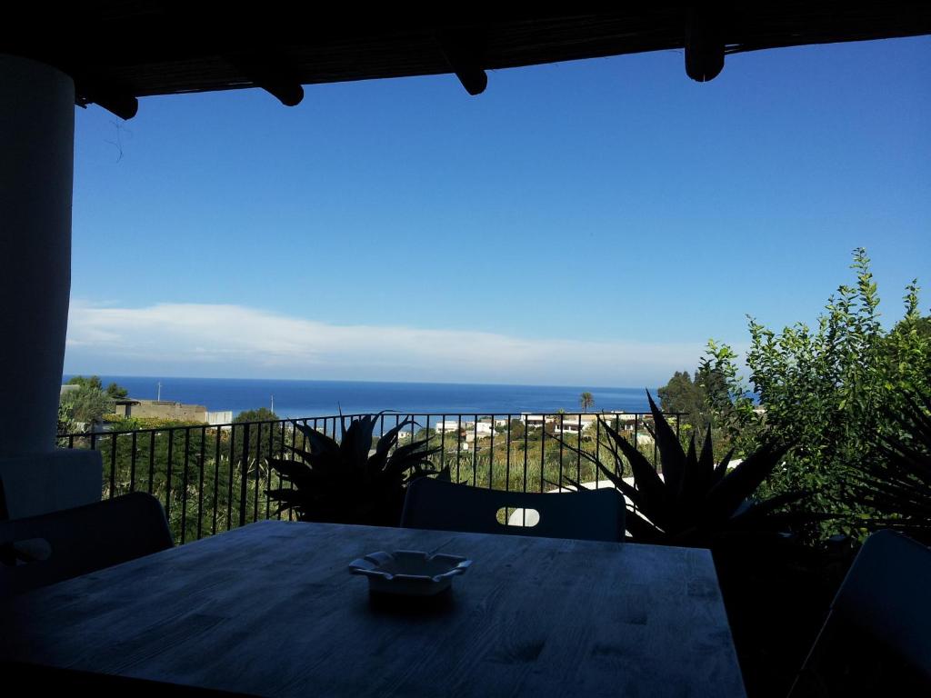 - une table sur un balcon avec vue sur l'océan dans l'établissement Villette Corallo, à Malfa