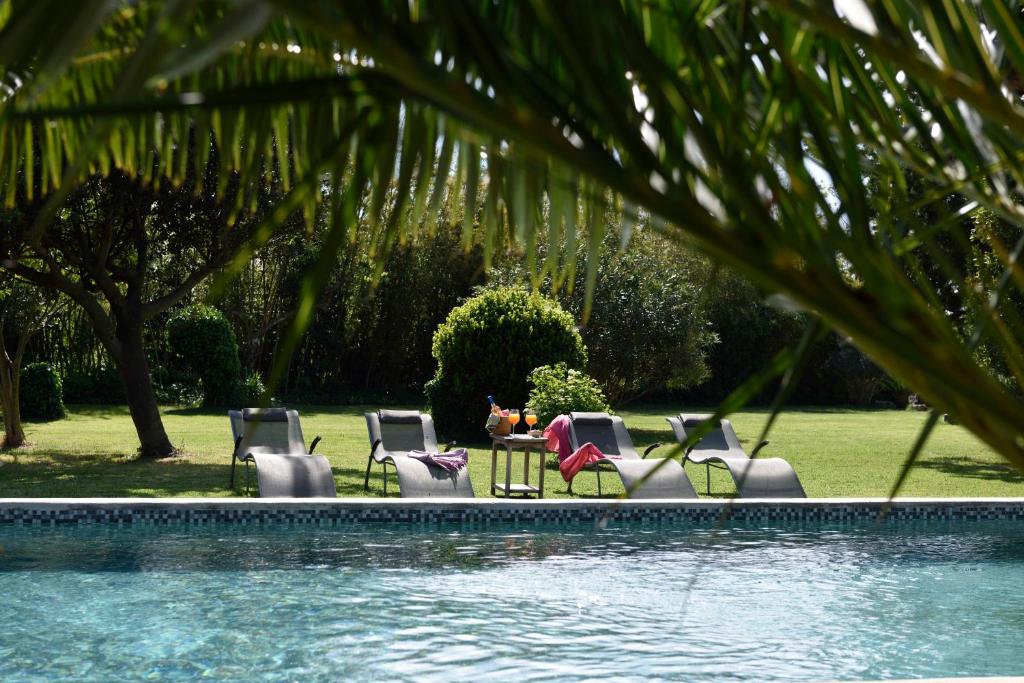 un grupo de sillas sentadas junto a una piscina en Mas de Bouvet en Camargue, en Albaron
