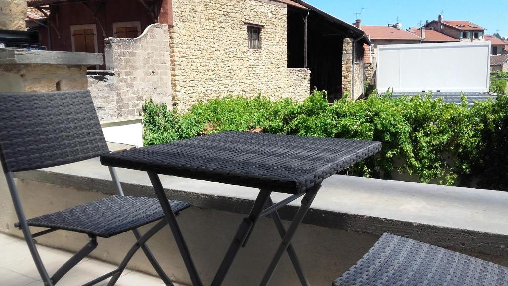 a black table and chair sitting on a balcony at Appart Hôtel Bourgoin in Bourgoin