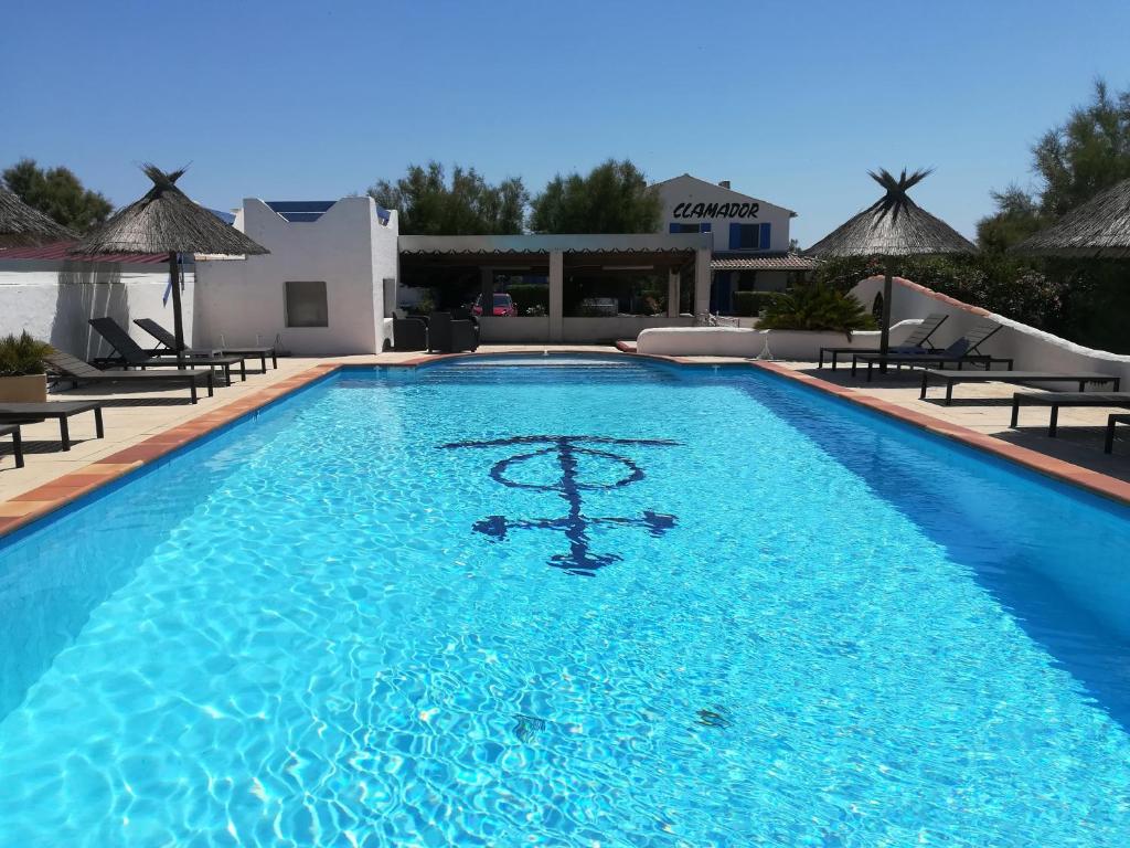una piscina con acqua blu in un resort di Clamador a Saintes-Maries-de-la-Mer