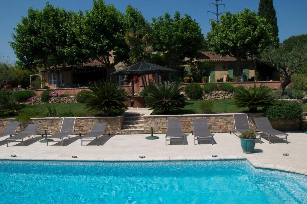 a swimming pool with lounge chairs and a house at Bastide de l'Avelan in Grimaud