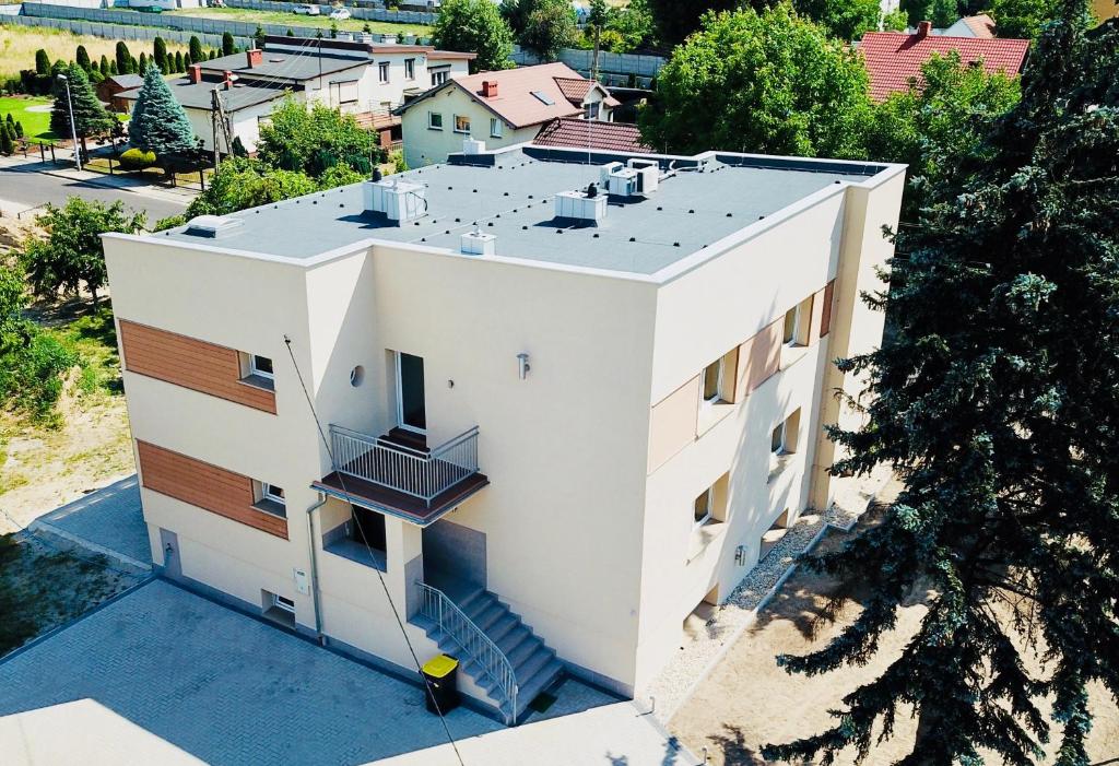 une vue aérienne sur une maison blanche avec un toit dans l'établissement Design Apartaments, à Ostrów Wielkopolski