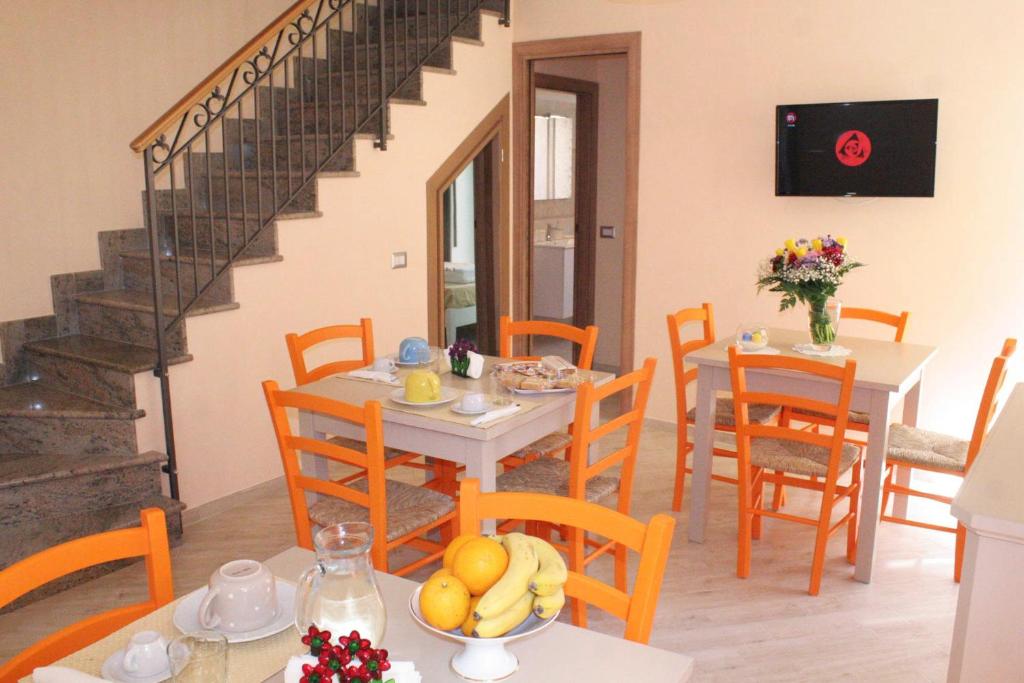a dining room with a table and chairs and a staircase at BB Aretè in Scilla