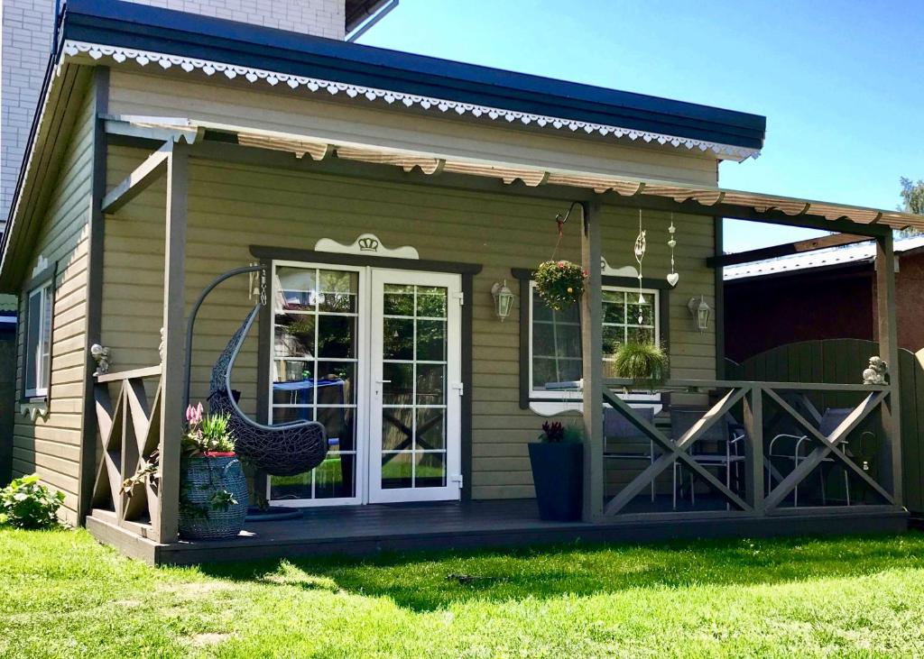 a small house with a porch and a door at Naujos statybos namelis in Palanga