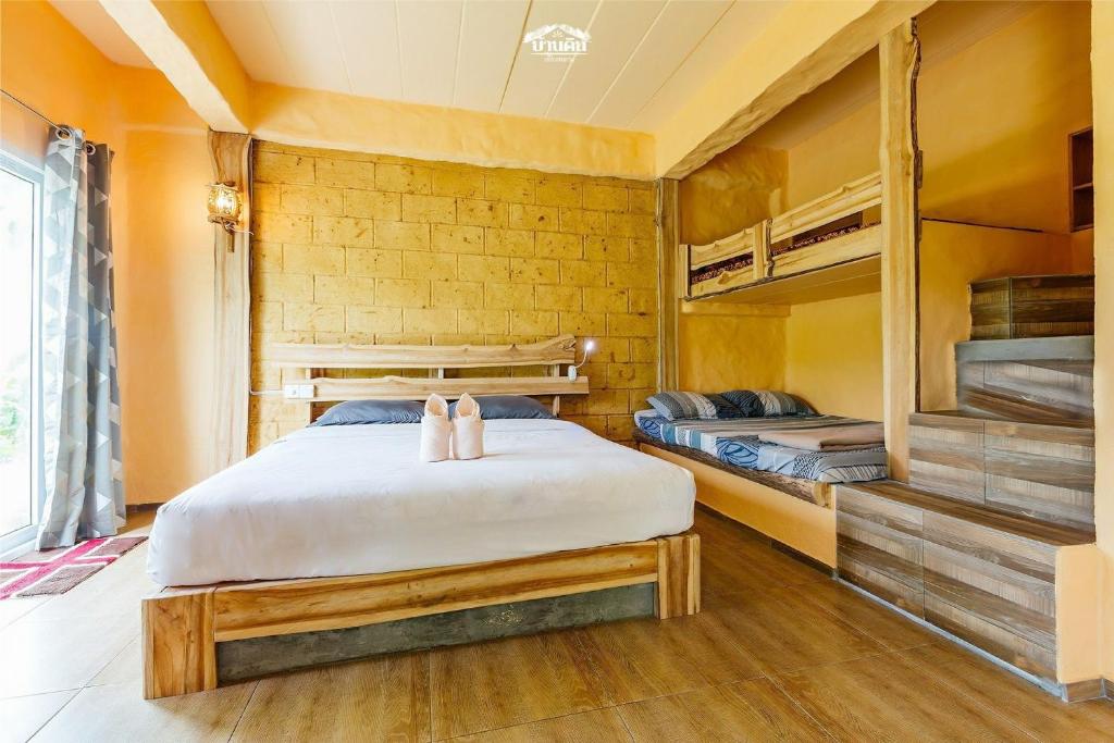 a bedroom with a bed and bunk beds at Baandin Chiewlarn in Ban Ta Khun