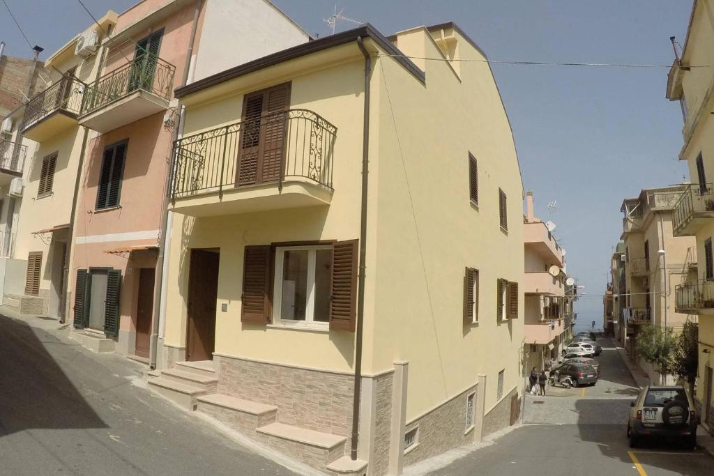 a white building with a balcony on a street at BB Aretè in Scilla