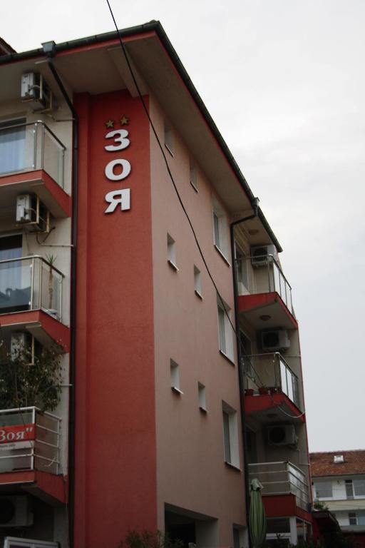 a building with a sign on the side of it at Zoya Guest House in Ravda