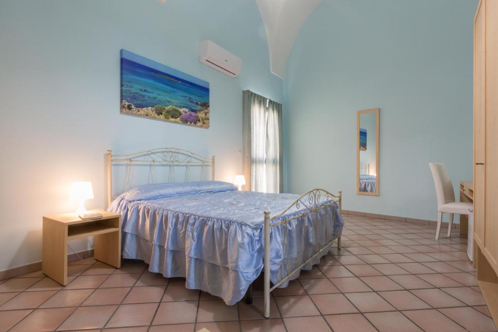 a bedroom with a bed and a table and a chair at Le Dimore dei Messapi in Ugento