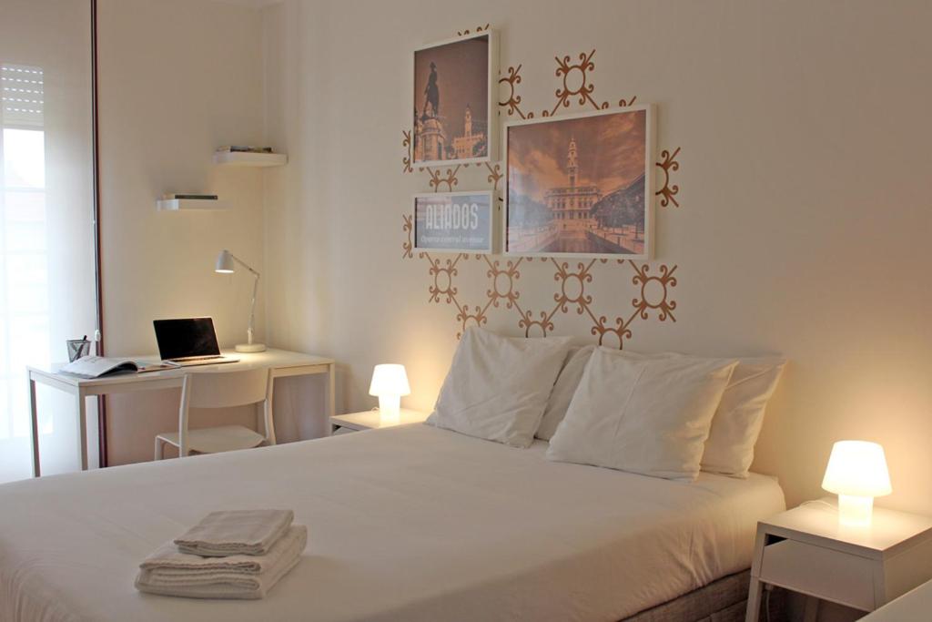 a bedroom with a bed and a desk with a laptop at Uporto House Villa in Porto