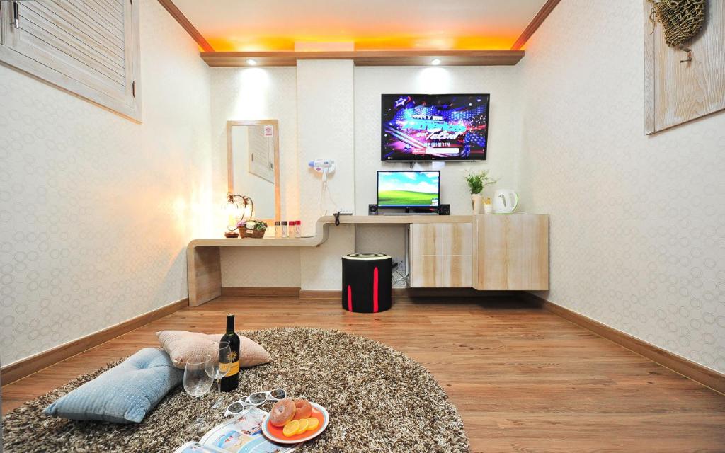 sala de estar con mesa y TV en Inje OST Motel, en Inje