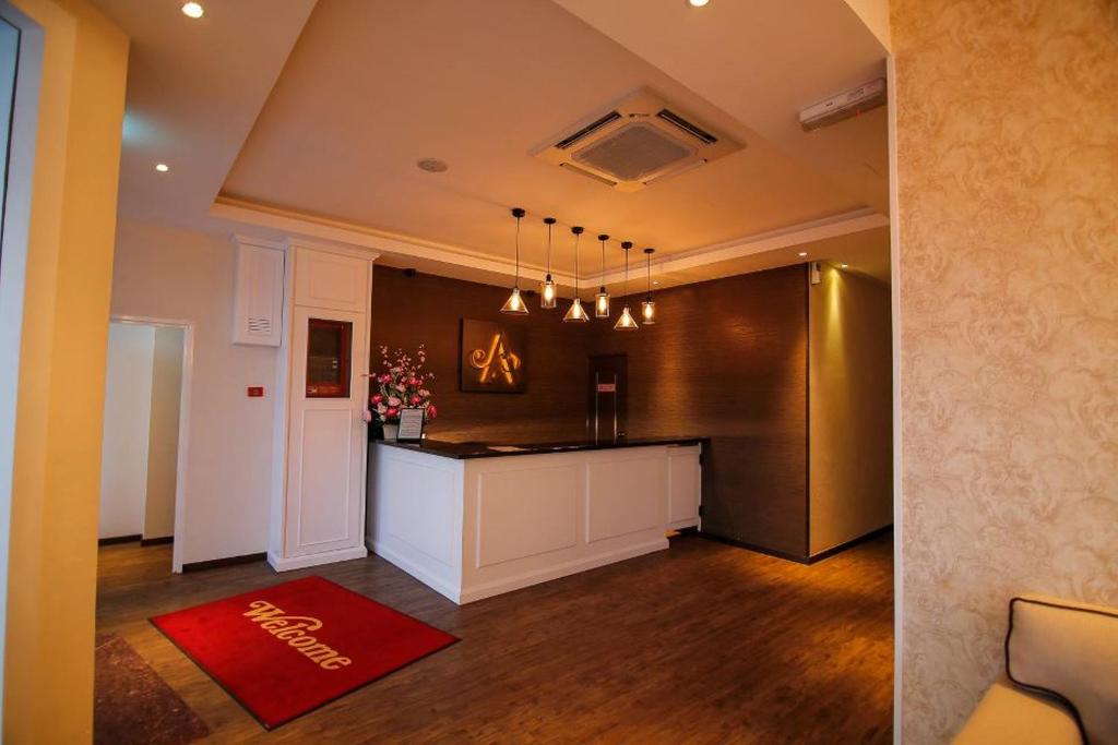 a kitchen with a counter and a red rug at Art Cottage Hotel in Ipoh