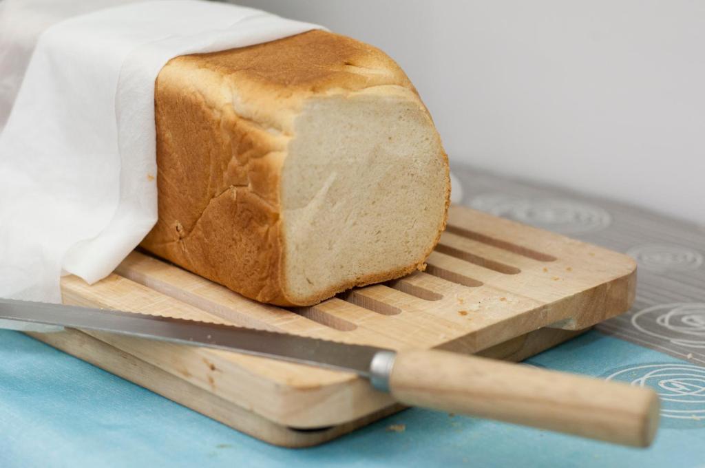 a loaf of bread on a cutting board with a knife at Hotel del Mar in Sottomarina