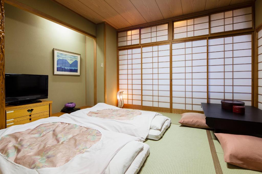Postel nebo postele na pokoji v ubytování Yamatoya Honten Ryokan Osaka