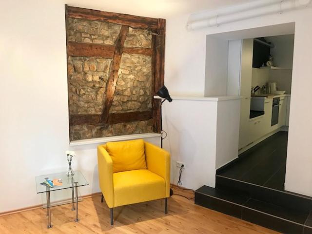 einen gelben Stuhl und einen Tisch in einem Zimmer in der Unterkunft Büdinger Hof in Weinheim