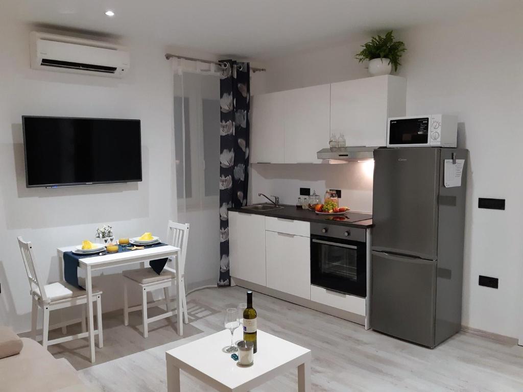Il comprend une cuisine équipée d'un réfrigérateur et d'une table avec des chaises. dans l'établissement Charmy Rovinj, à Rovinj