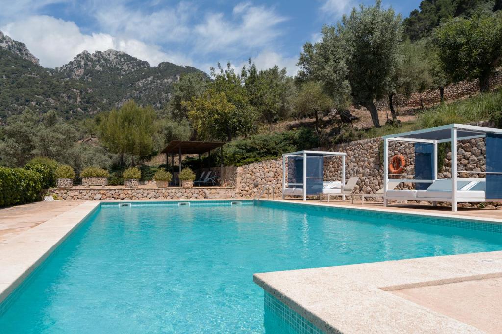 una piscina en una villa con montañas en el fondo en Alfabia Nou Agroturismo en Bunyola
