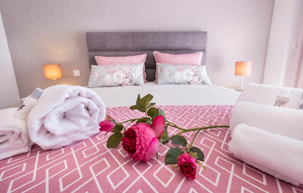 een roze slaapkamer met een bed met rozen erop bij Alto das Nogueiras House Fátima in Fátima