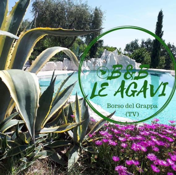 een bord voor een resort met bloemen voor een zwembad bij B&B LE AGAVI in Borso del Grappa