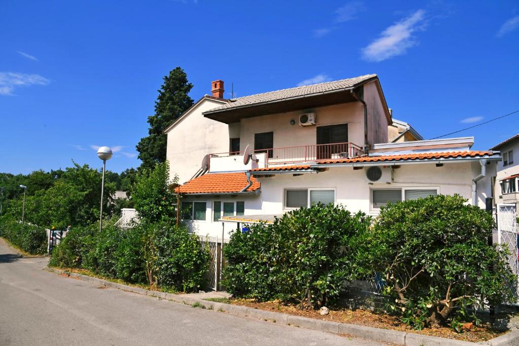 a white house with a balcony on a street at Trsatika in Rijeka