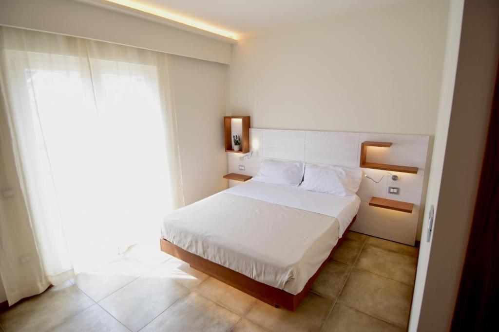 a bedroom with a white bed and a large window at B&B Maestrale in Tropea