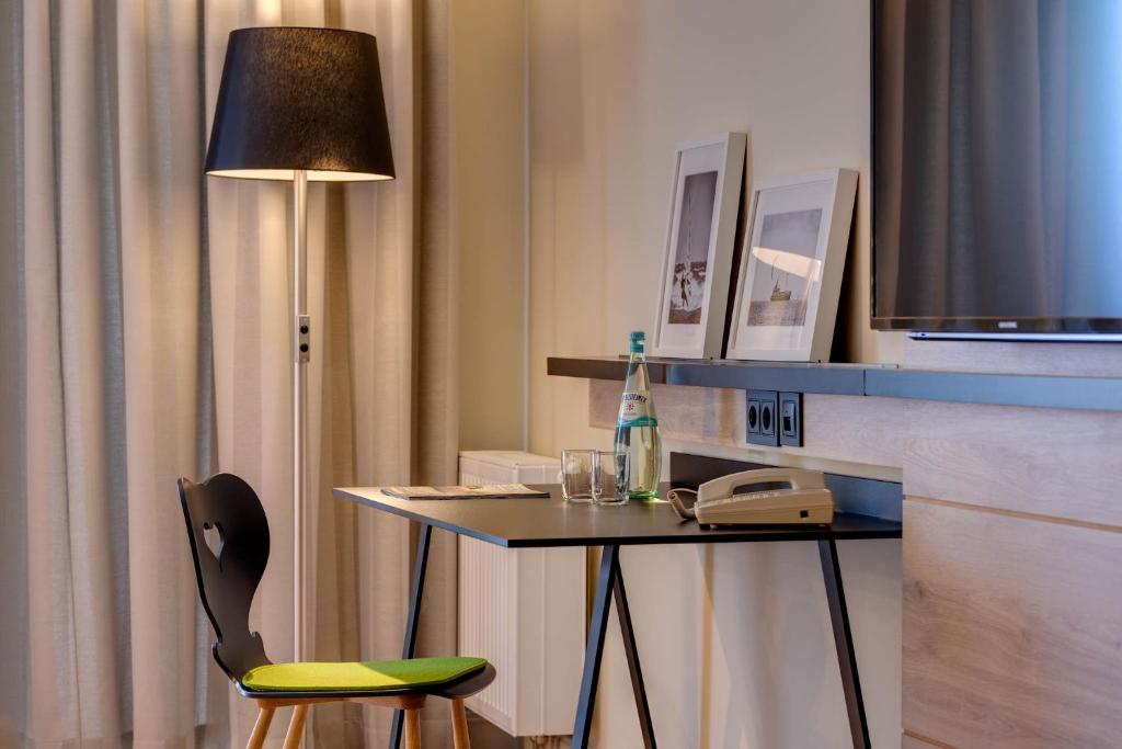 a room with a table with a phone and a lamp at Hotel Restaurant Burg-Klause in Burg auf Fehmarn