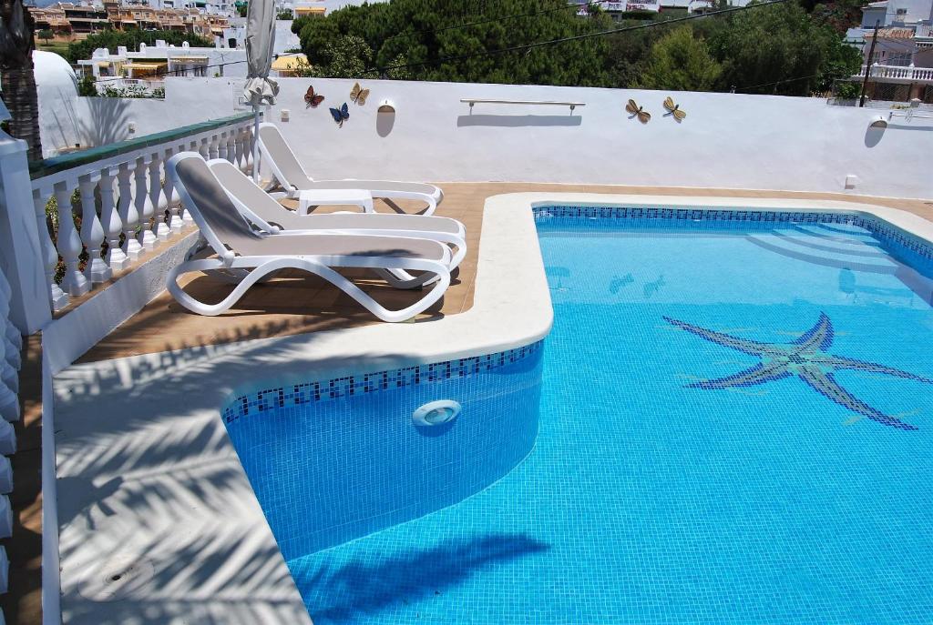 een zwembad met twee stoelen en een zeester erop geschilderd bij Villa Sandra Top Floor Escape in Nerja