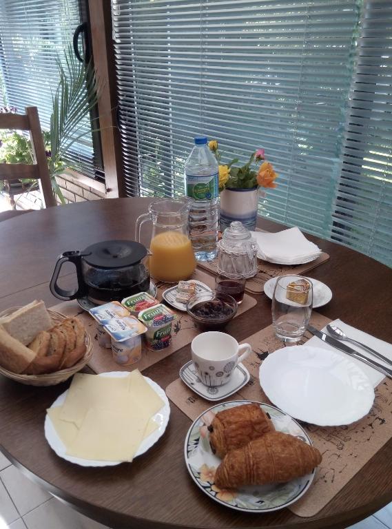 a table with breakfast foods and drinks on it at chez Myla chambre avec tv écran plat et salle de bain privative in Bourges