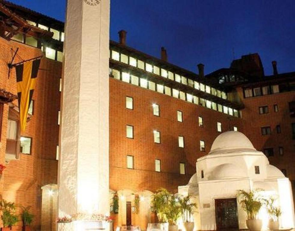 une tour d'horloge devant un grand bâtiment dans l'établissement Estelar Apartamentos Bogotá - La Fontana, à Bogotá