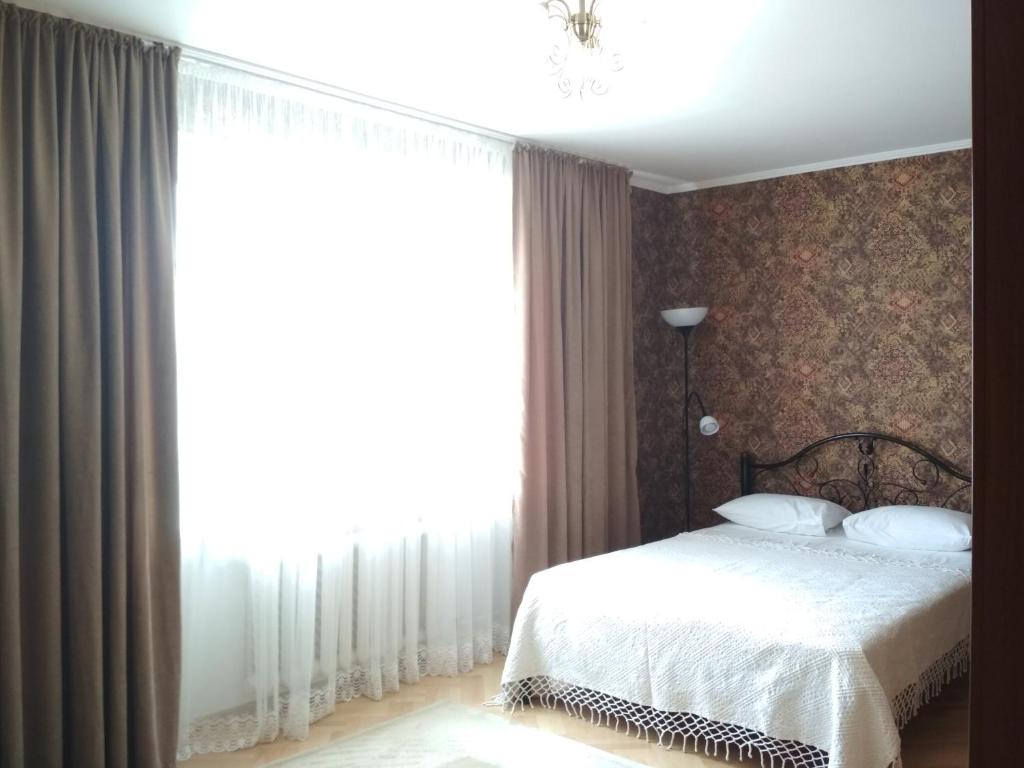 um quarto com uma cama e uma grande janela em New Apartment with 2 Isolated Bedrooms em Lviv