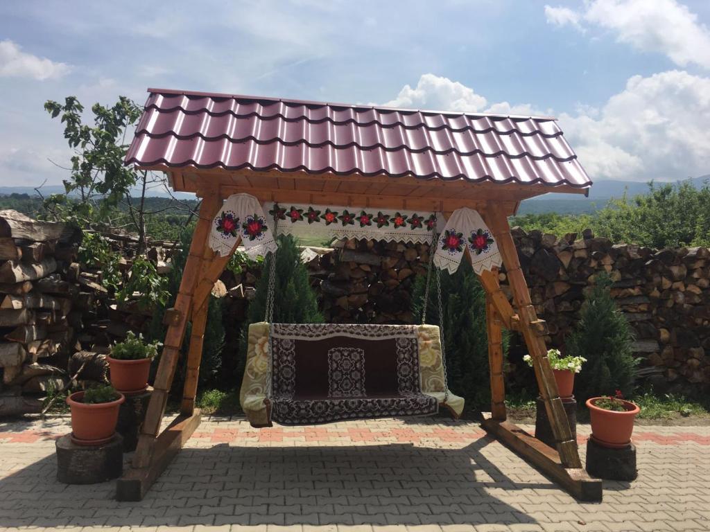 einen Pavillon mit einer Bank im Hof in der Unterkunft Pensiunea Crinul Alb in Deseşti