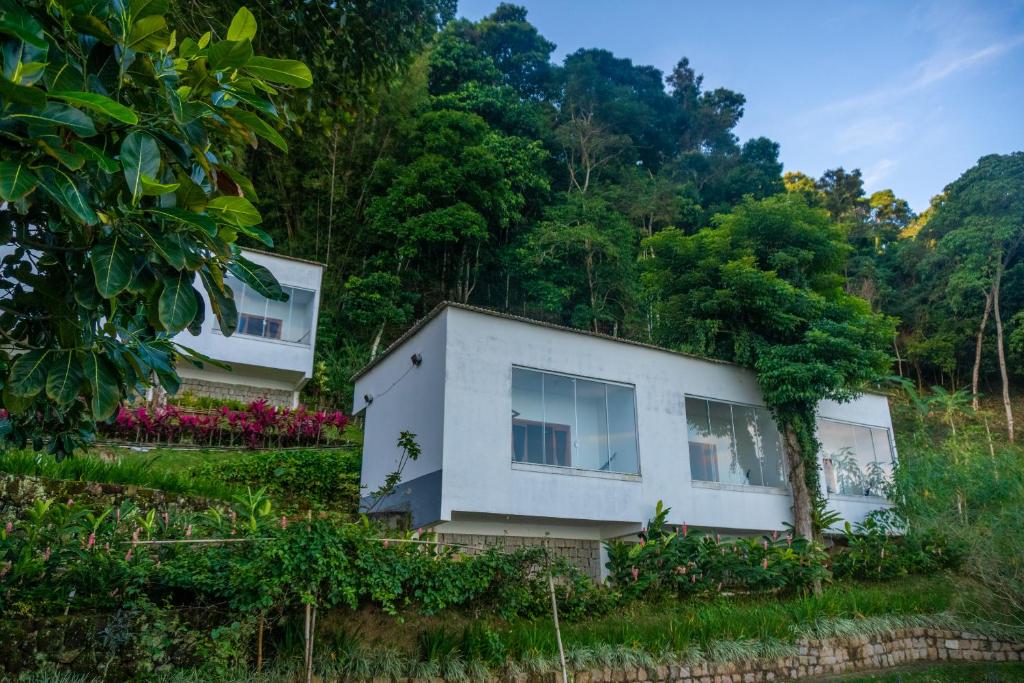una casa en una colina con árboles en el fondo en Pousada Piquara en Mangaratiba