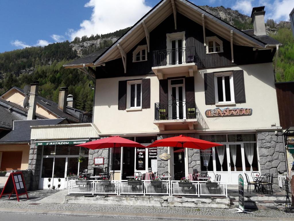 un restaurante con sombrillas rojas frente a un edificio en Chambres d'hôtes L'Astazou, en Gavarnie