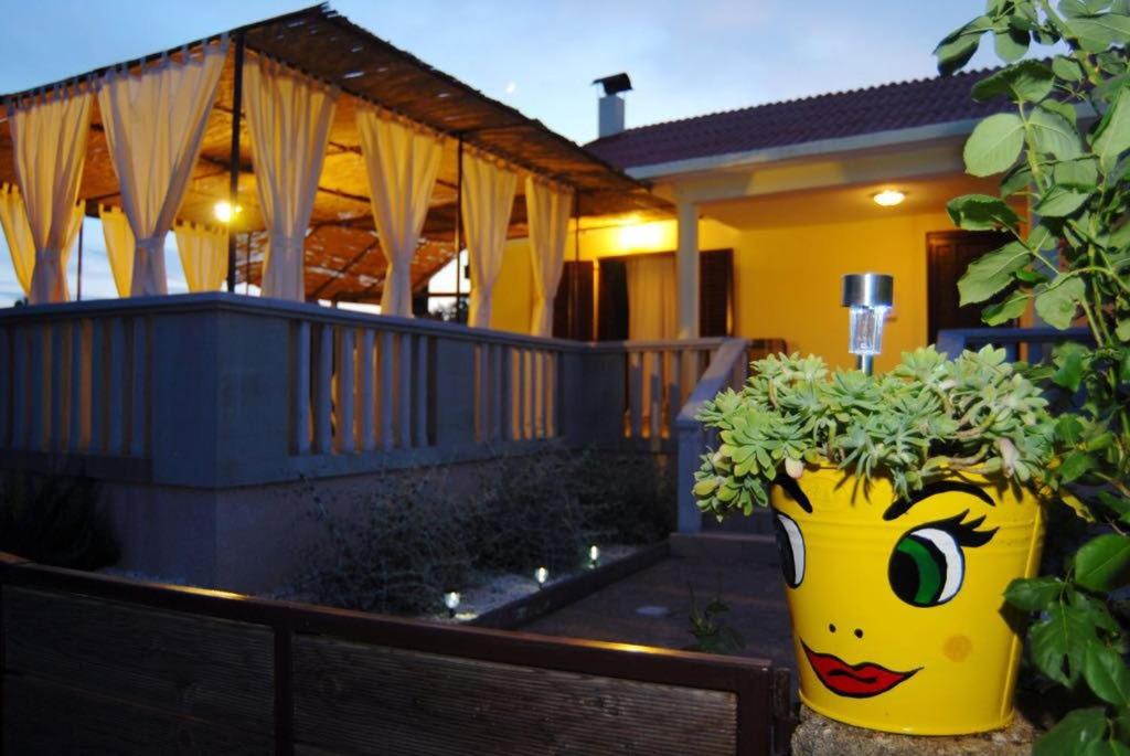 eine große gelbe Vase mit einem Gesicht auf einem Haus in der Unterkunft Kuća za odmor Dido Ive in Ugljan