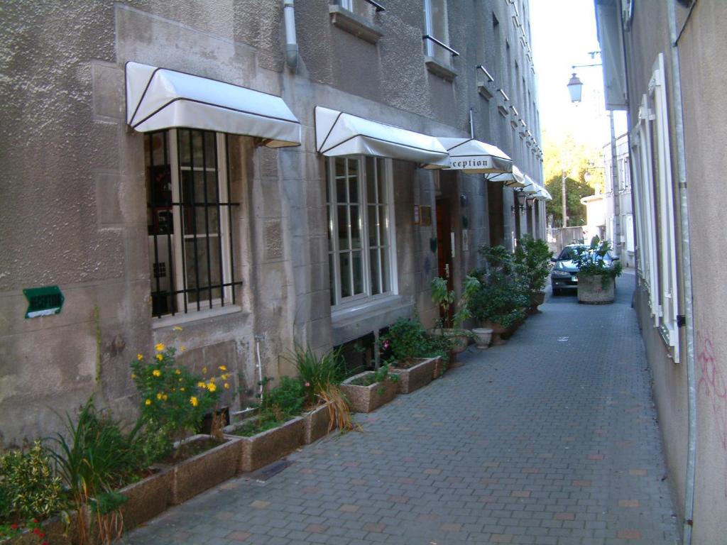 an alley with umbrellas on the side of a building at A La Porte Saint Jean in La Souterraine