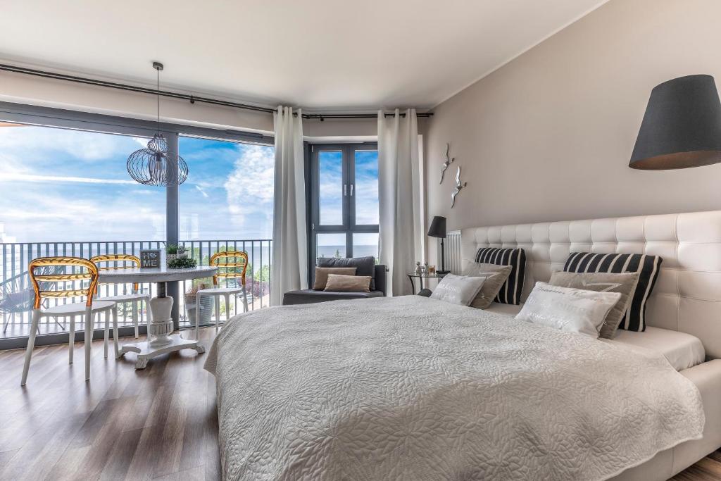 Apartament Prestige & Sea Horyzont 613 في مينززدرويه: غرفة نوم بسرير وطاولة وكراسي